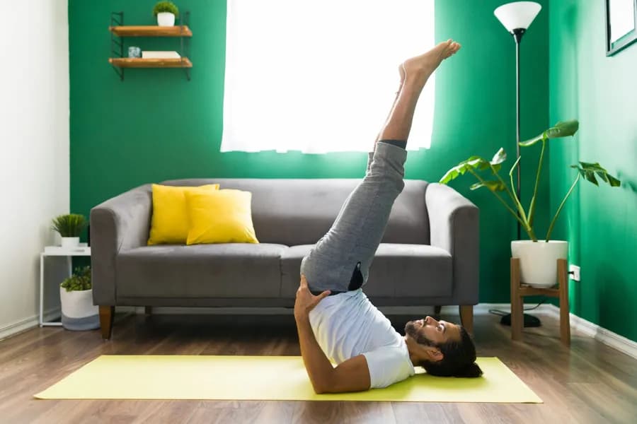 Man balancing during Sarvangasana (Shoulder Stand) practice