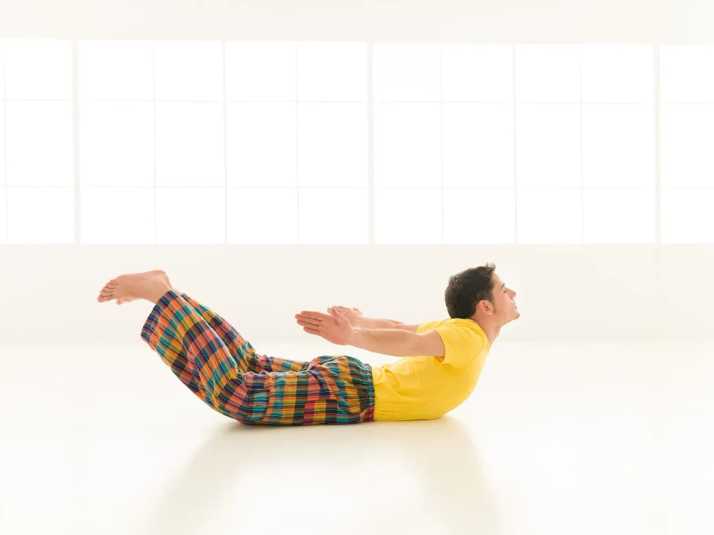 Man practicing yoga in Shalabhasana (Locust Pose)