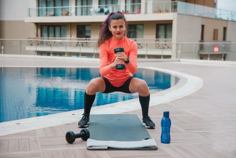 active-woman-doing-squats-outdoors-with-dumbbells-2026-01-07-00-29-53-utc.jpg