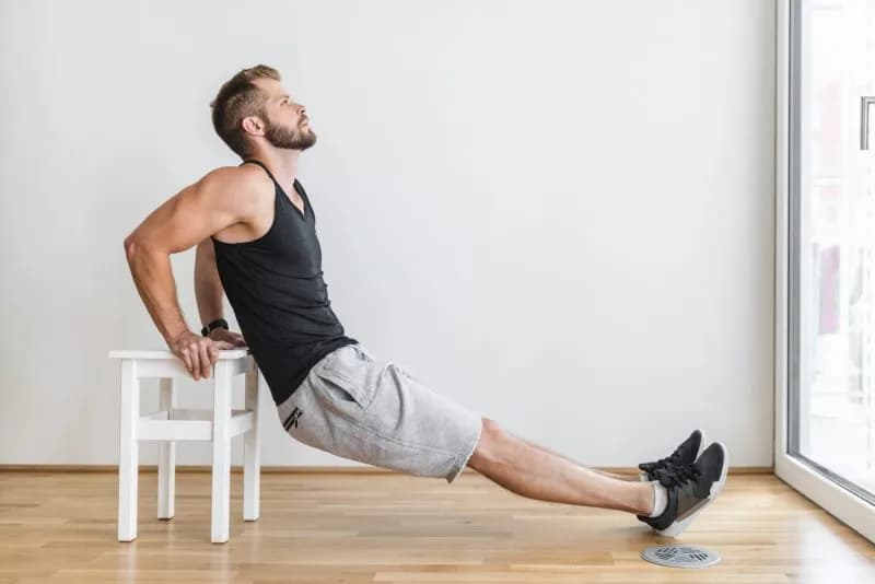 athletic-man-does-dips-at-home-on-chair-2026-03-09-04-35-18-utc.jpg