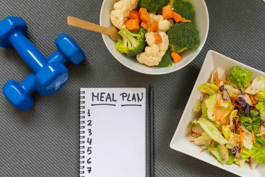 Healthy meal prep with dumbbells representing the best diet plan for muscle building
