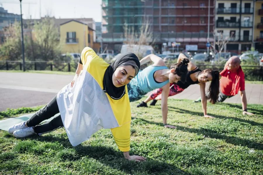 Calisthenics class at outdoor gym, women and man