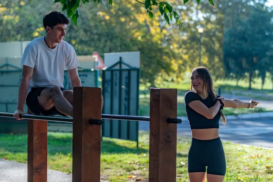 Couple exercising on outdoor equipment in a park