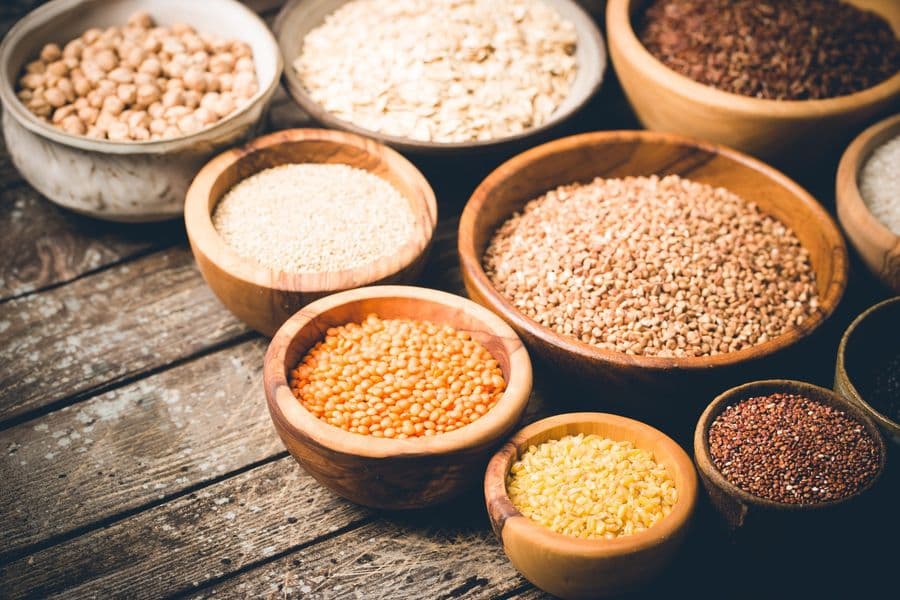 Assorted dried grains and legumes soaking in wooden bowls