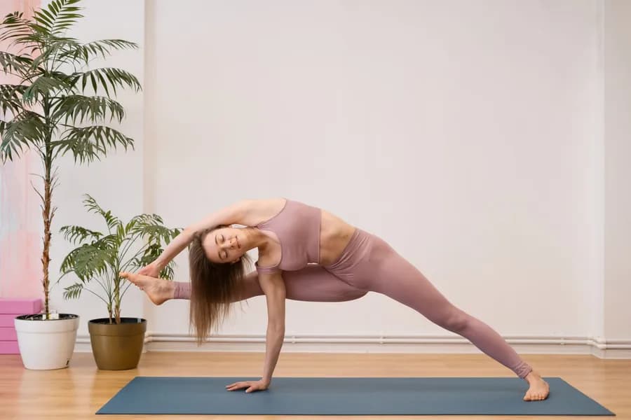 Woman practicing yoga pose on a mat at home