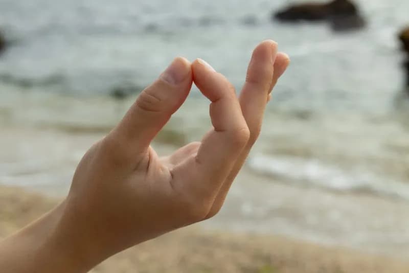 fingers folded in zen sign on seashore close up 2026 01 09 07 57 26 utc 2