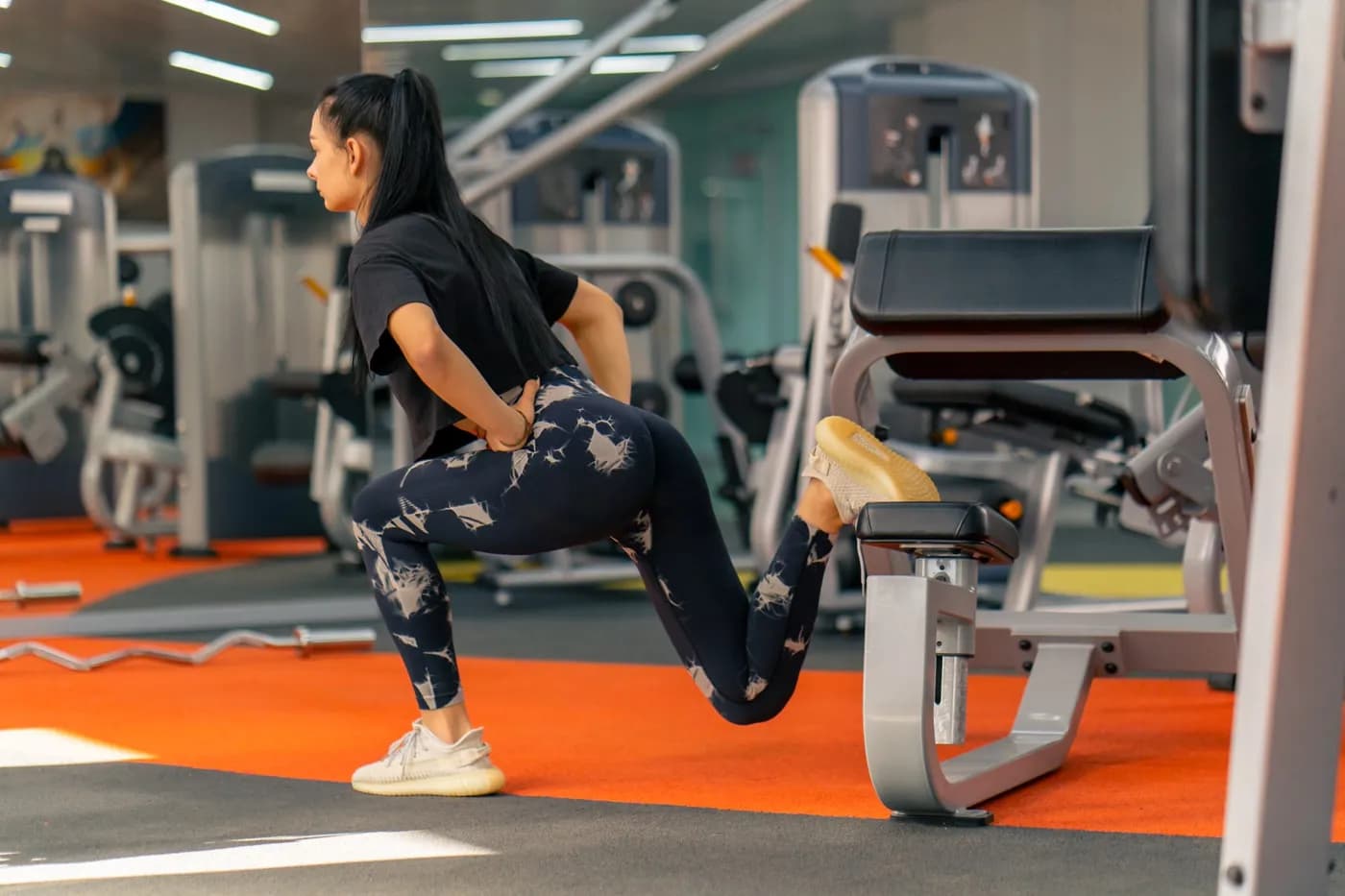 Woman in sportswear doing squats in the gym for glute strength