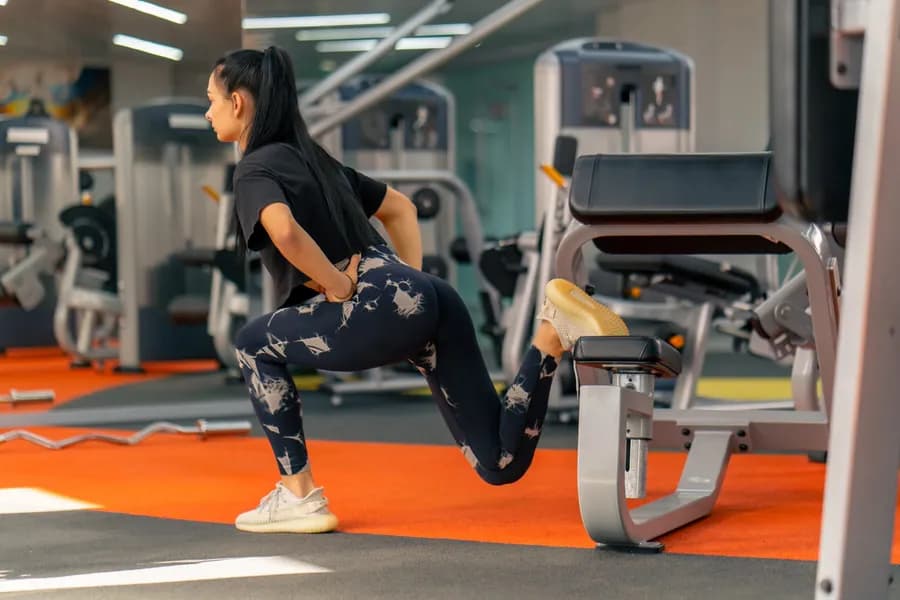Woman in sportswear doing squats in the gym for glute strength