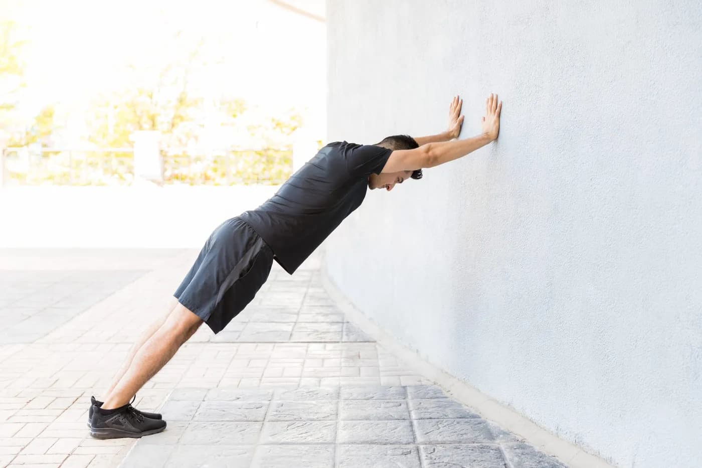 Athletic man stretching outdoors on a sunny day