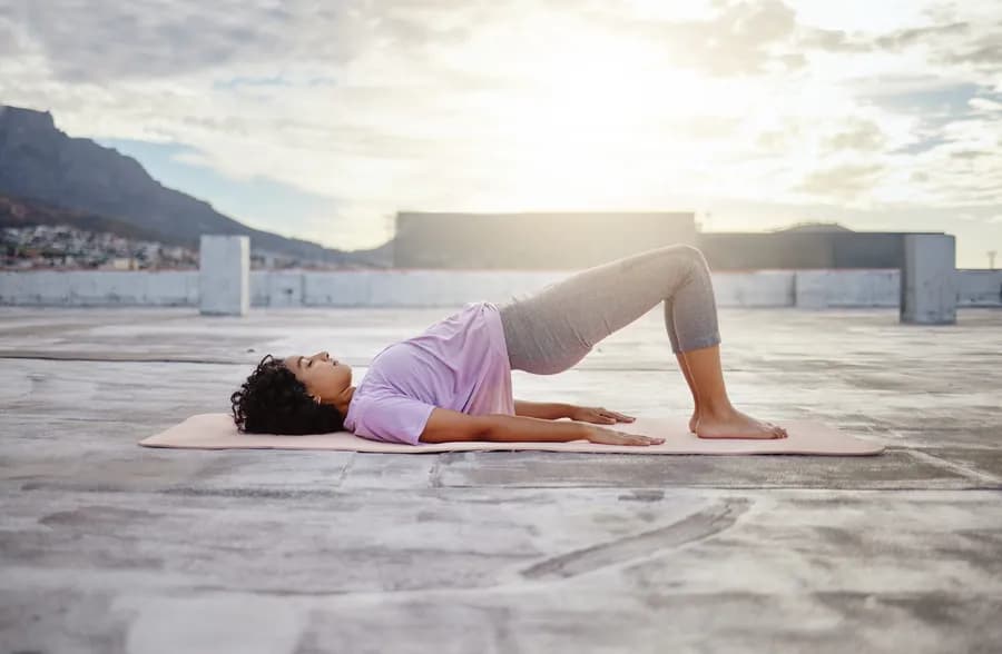 Woman performing a hip thrust exercise as part of a pelvic floor strengthening routine