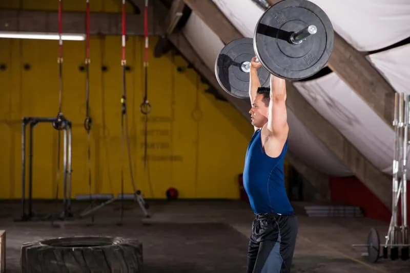 A man lifting weights during strength training for muscle gain