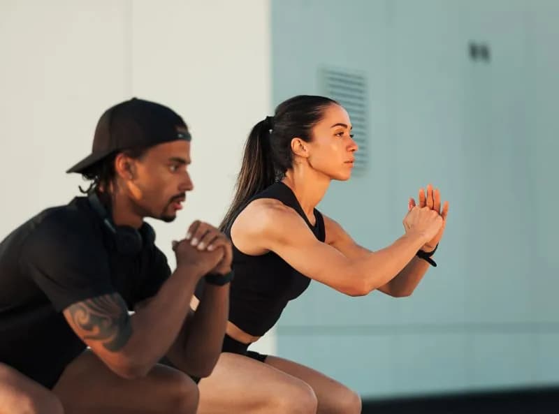 side-view-of-two-athletes-doing-squats-at-sunset-2026-03-19-09-28-07-utc.jpg