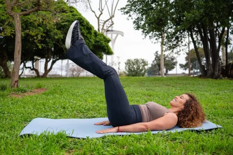 smiling-woman-exercising-in-park-on-yoga-mat-2026-06-16-06-30-31-utc.jpg