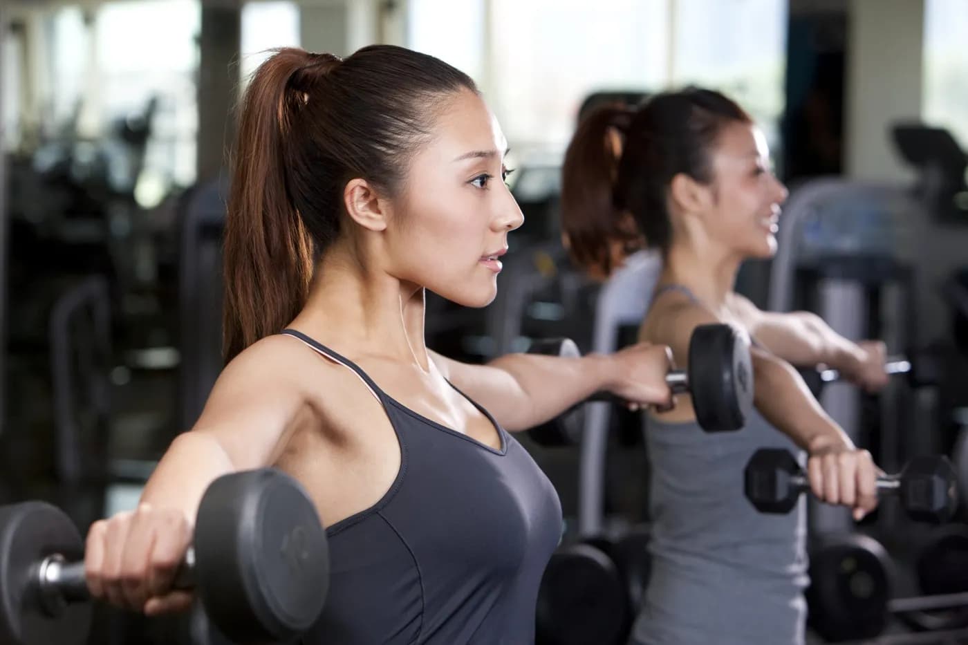 Woman working out with dumbbells in a gym