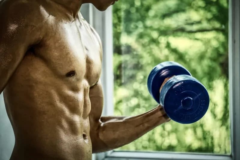 toned-man-lifting-dumbbell-by-a-window-2026-01-07-07-28-13-utc.jpg
