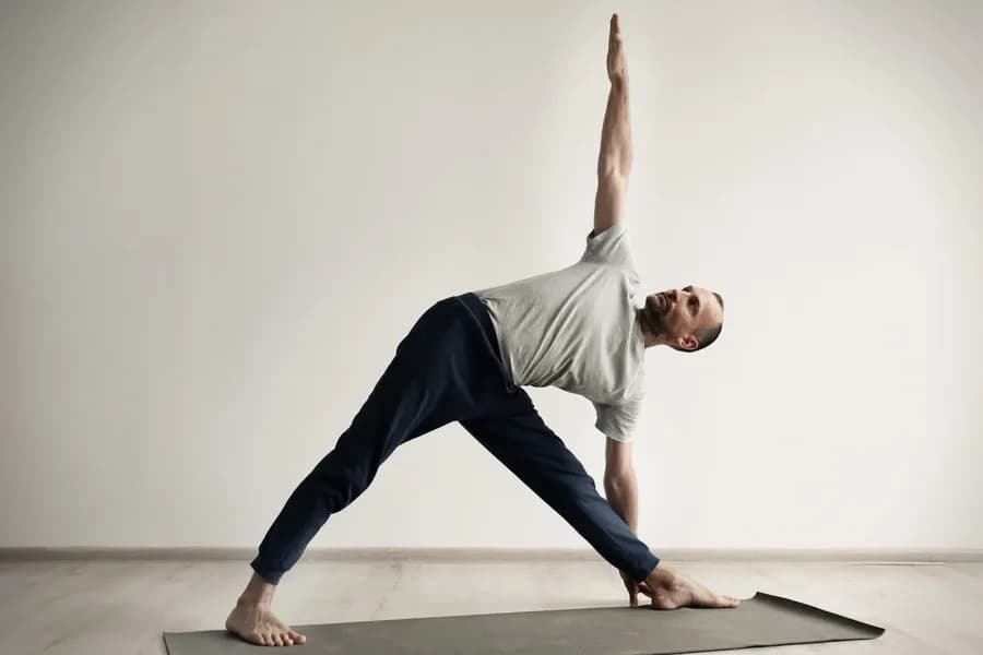 Person practicing yoga indoors in triangle pose
