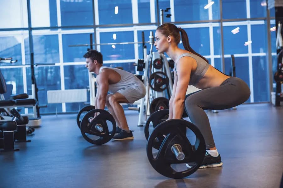 Person performing compound strength exercises at the gym