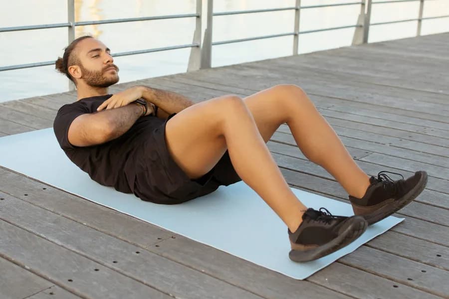 Man doing crunches exercise on a mat to build core strength