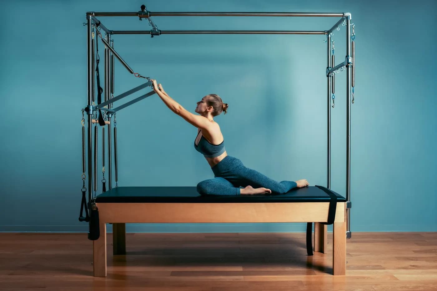 Woman performing pilates exercise on a reformer machine