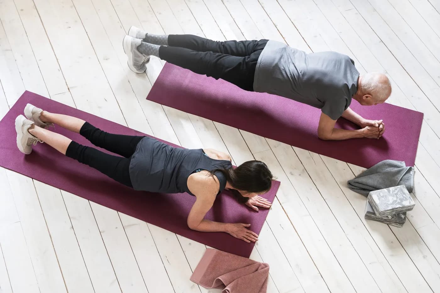 Woman and senior man exercising in home gym