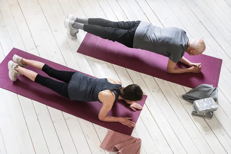 Woman and senior man exercising in home gym