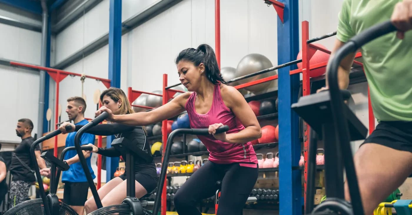 Athletes training on exercise bikes at the gym