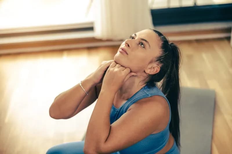 Woman doing neck and shoulder stretches to prepare for Brahma Mudra practice