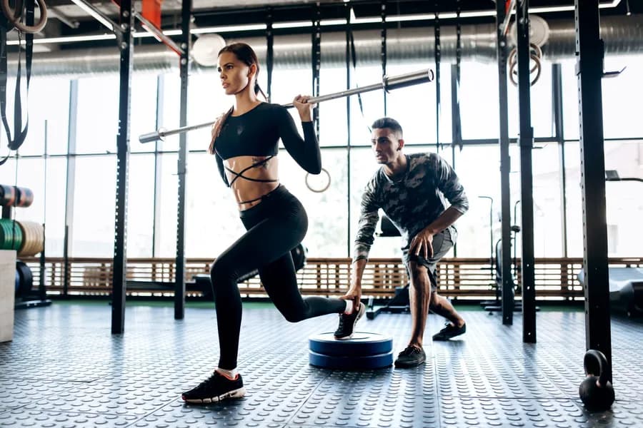 woman-lifts-weights-with-trainer-at-indoor-gym-2026-01-05-00-38-58-utc.jpg