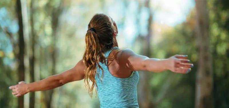 woman stretching arms in nature wellbeing concept 2026 03 10 02 09 07 utc